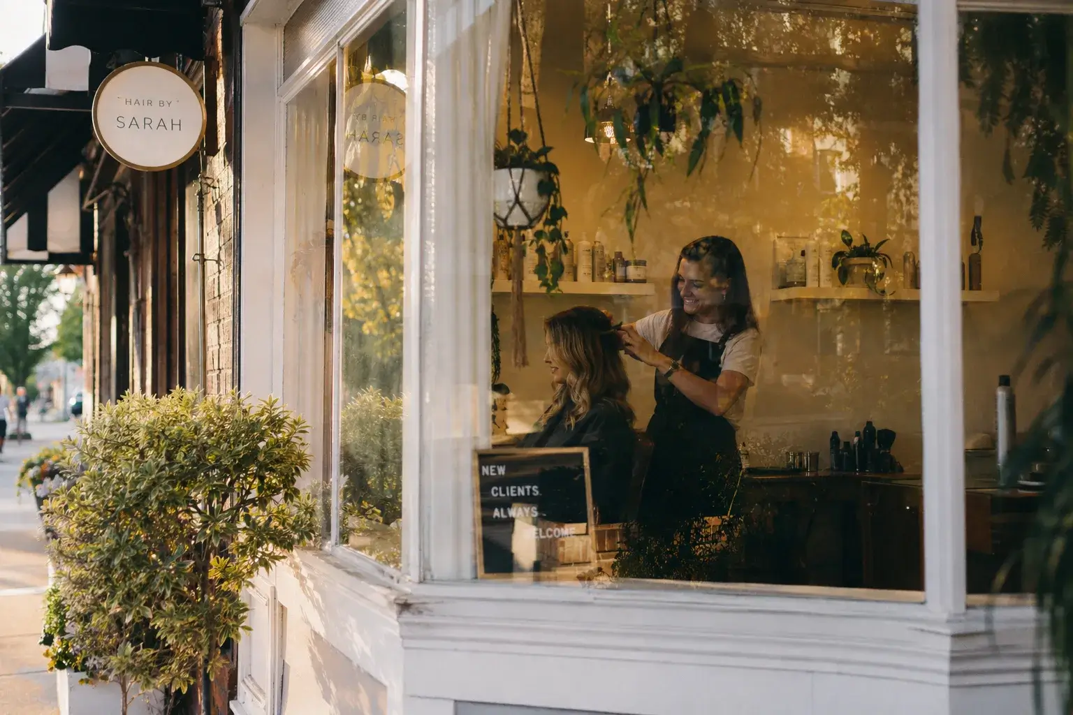 A view through the window of a cozy, modern corner hair salo